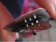 A side view of a Karash pendant with rivets