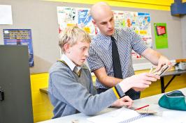 Technology teacher and student checking work together