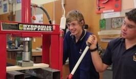 Students test materials using a hydraulic press.