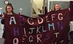 Students holding their sunshade deck curtain with letters 