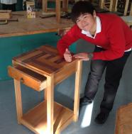 A student displays his coffee table and gives a thumbs up